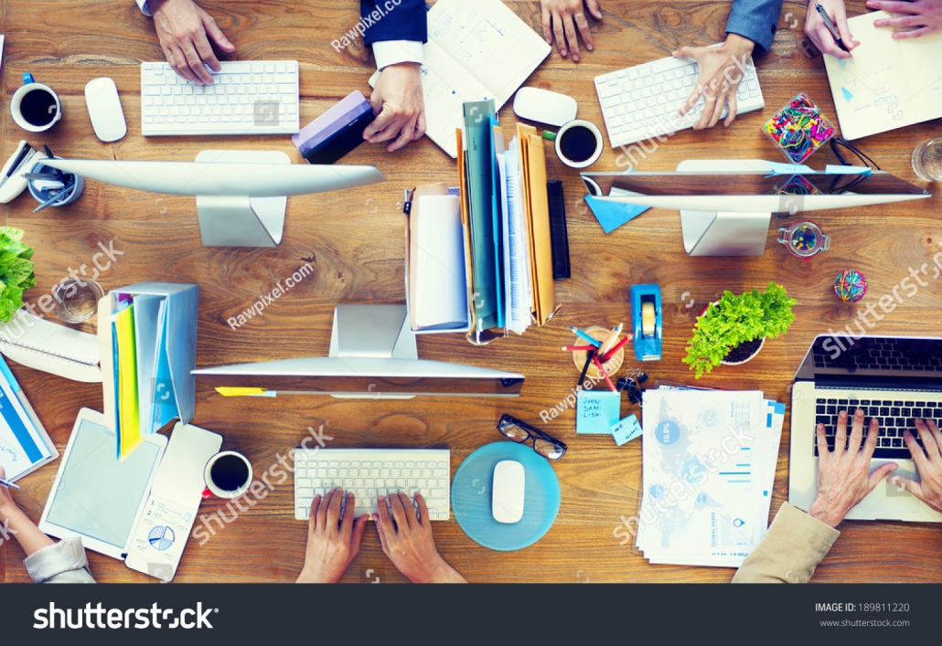 stock-photo-group-of-business-people-working-on-an-office-desk-189811220